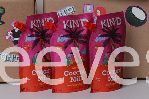 Cardboard boxes with KIND Coconut Milk packaging on a white background